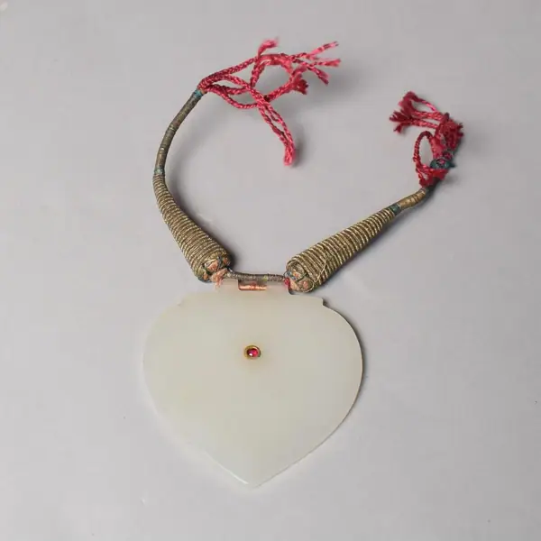 An amulet pendant, heart shaped, white nephrite jade, inset ruby, gold setting, India