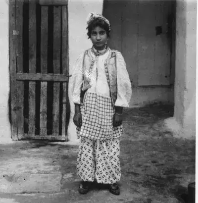Jewish girl in wide pants with amulet over her shoulder