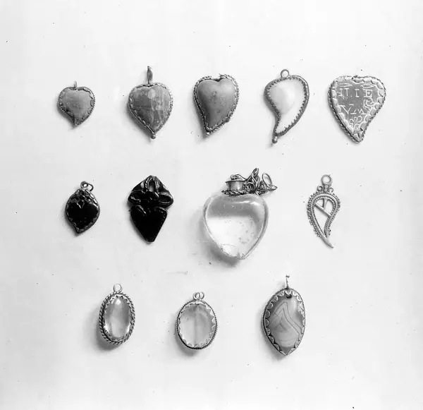 M0016765: Spanish amulets: heart forms and eye forms made from stone, shell, slate, jet, glass, silver and agate