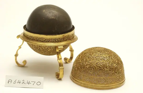 An artificially manufactured version of a goa stone found inside the stomachs of an animal (bezoar stones) and its case. Made in India from a paste of clay, crushed shell, amber, musk and resin and us