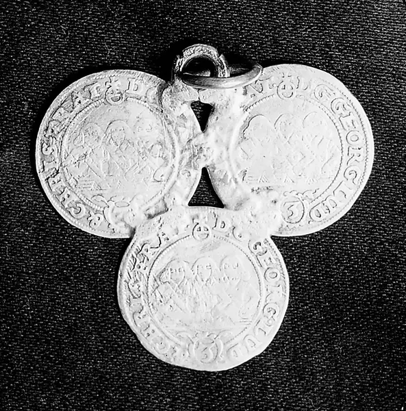 M0016852: Three silver coins joined to form a triangle / M0016853: St. Benedict's penny with a representation of the saint / M0016854: The cross of St. Ulrich: Maltese shaped cross, with scene showing