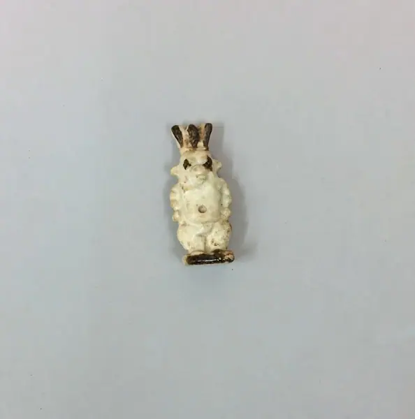 Bes amulet, white and brown glazed composition, Saft el-Henna, Egypt, Late Period, Dynasty Twenty-six