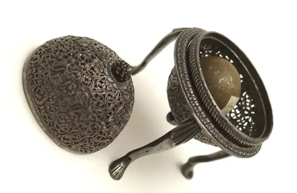 An artificially manufactured version of a goa stone found inside the stomachs of an animal (bezoar stones) and its case. Made in India from a paste of clay, crushed shell, amber, musk and resin and us