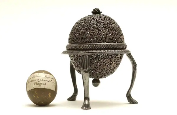 An artificially manufactured version of a goa stone found inside the stomachs of an animal (bezoar stones) and its case. Made in India from a paste of clay, crushed shell, amber, musk and resin and us