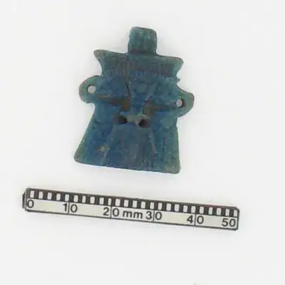 This object is a small blue faience representation of the god Bes, with a hole through the top for use as a pe