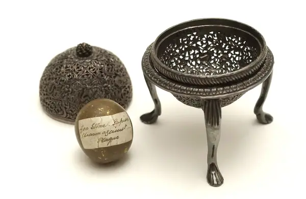 An artificially manufactured version of a goa stone found inside the stomachs of an animal (bezoar stones) and its case. Made in India from a paste of clay, crushed shell, amber, musk and resin and us