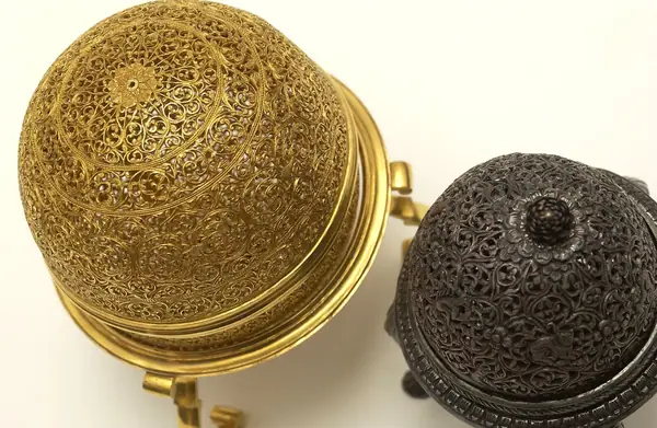 An artificially manufactured version of a goa stone found inside the stomachs of an animal (bezoar stones) and its case. Made in India from a paste of clay, crushed shell, amber, musk and resin and us