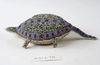 Sioux Indian amulet in the form of a turtle, worn by girls to ward off illness. Said to contain the umbilical cord of the wearer. Decorated in beading. Northern Plains