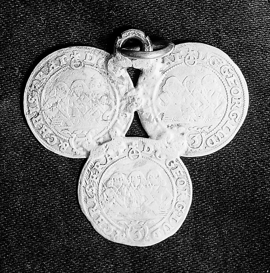 Three silver coins joined in a triangle