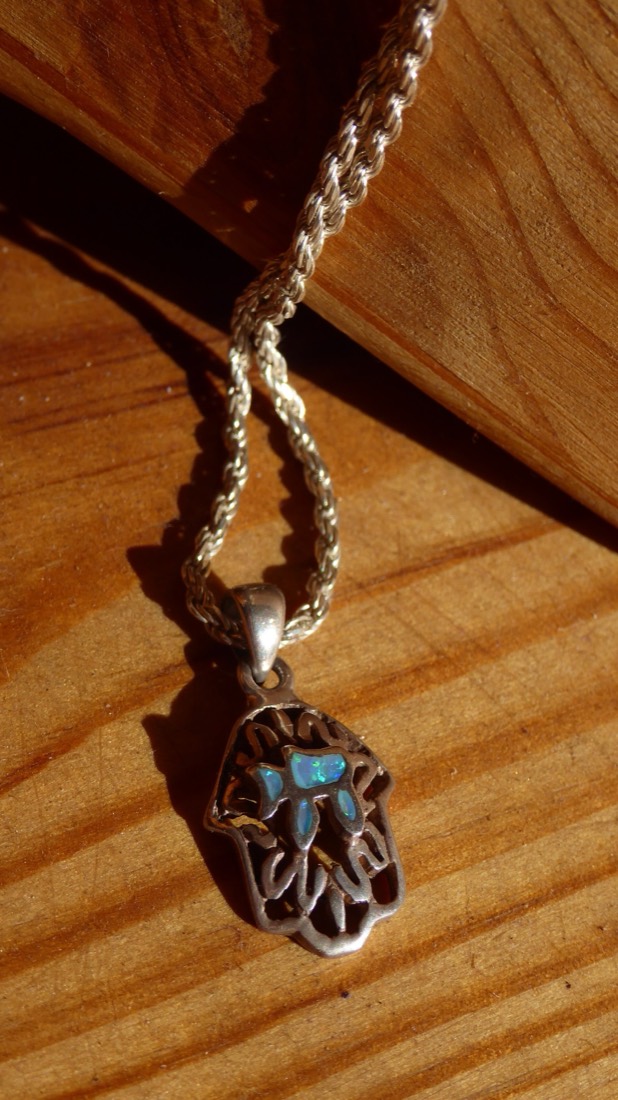 A silver hamsa with chai